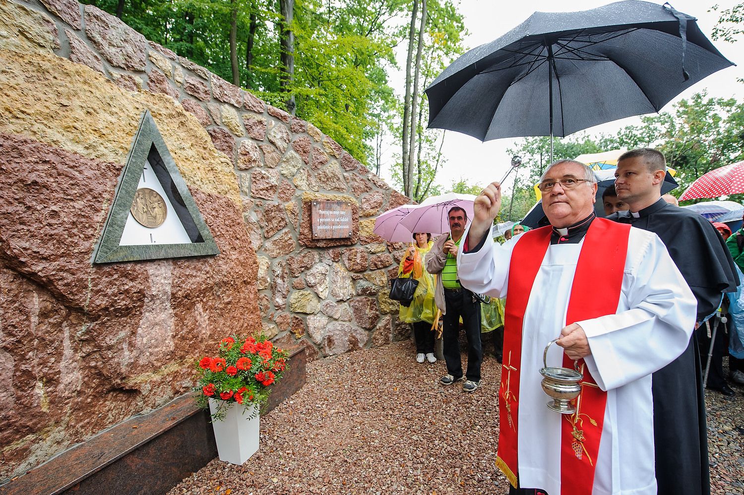 Biskup požehnáva zastavenie krížovej cesty v daždi
